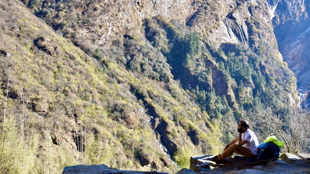 Trekker resting in the lap of mountain