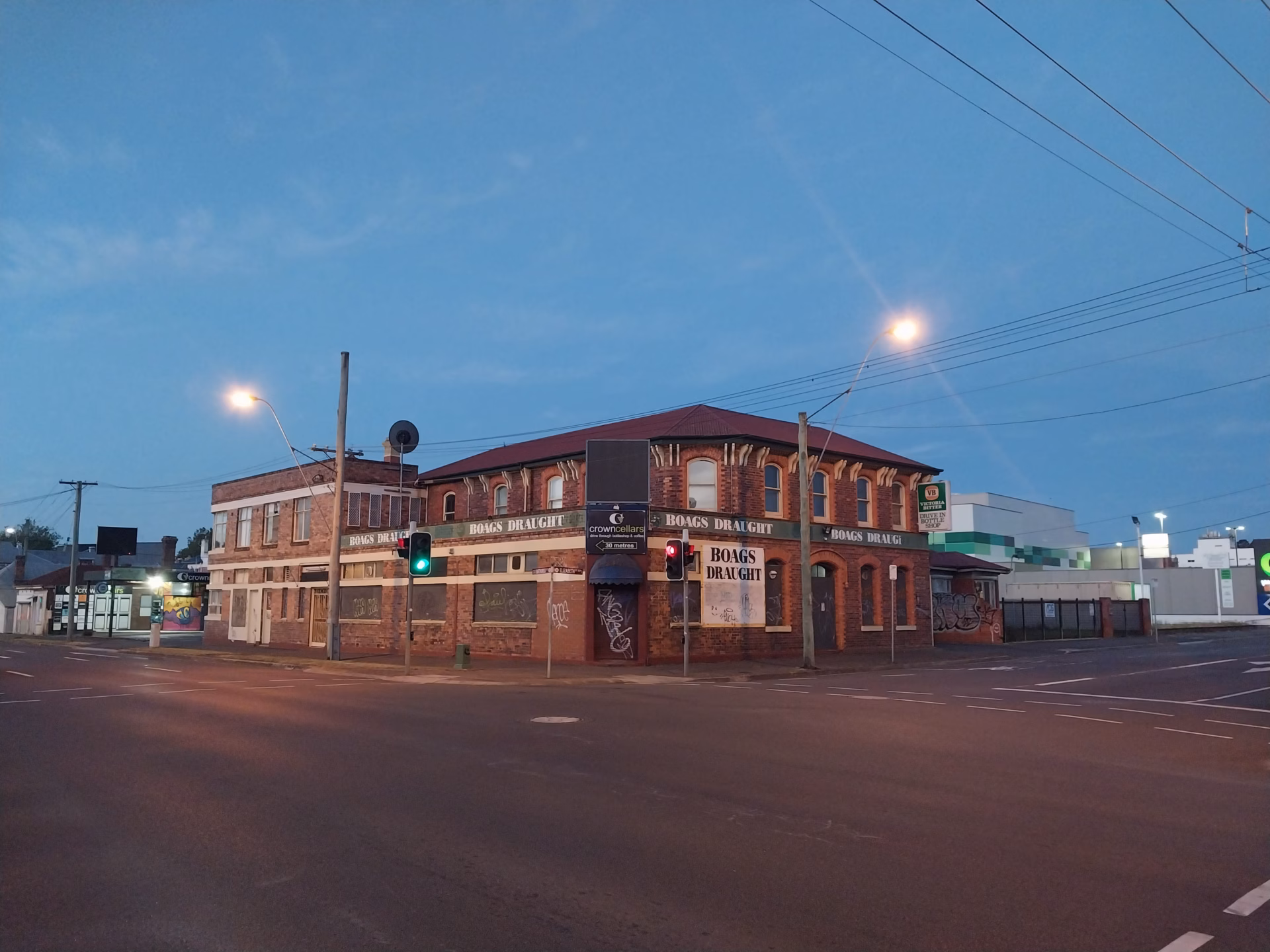 A historic red brick Victorian corner pub advertising Boags Draught beer photographed at dusk in Launceston Tasmania with blue hour sky