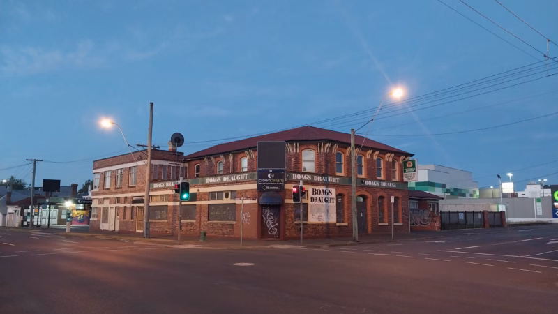 A historic red brick Victorian corner pub advertising Boags Draught beer photographed at dusk in Launceston Tasmania with blue hour sky