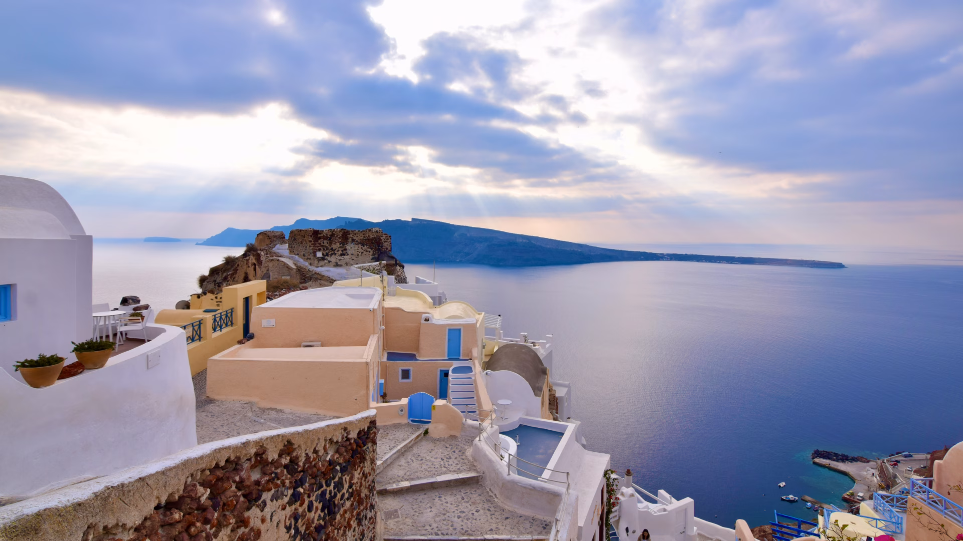 Oia village in Santorini with iconic blue-domed church and white cliffside houses overlooking the caldera