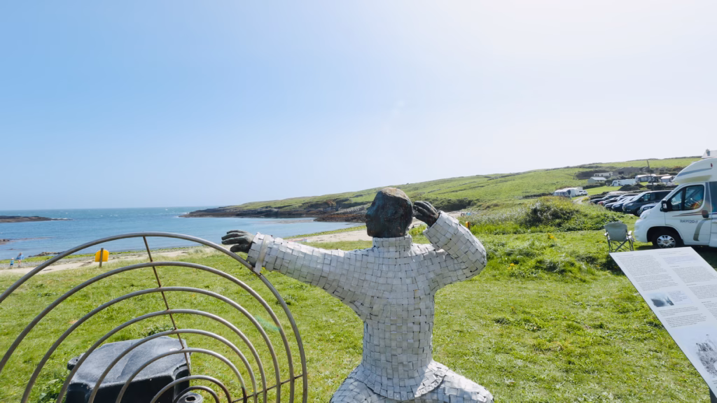 Marconi sculpture at Galley Cove Beach — figure with arms raised toward a radio dish facing the Atlantic