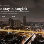 Aerial night view of Bangkok's skyline with an illuminated elevated expressway curving past high-rise condos near the Chao Phraya