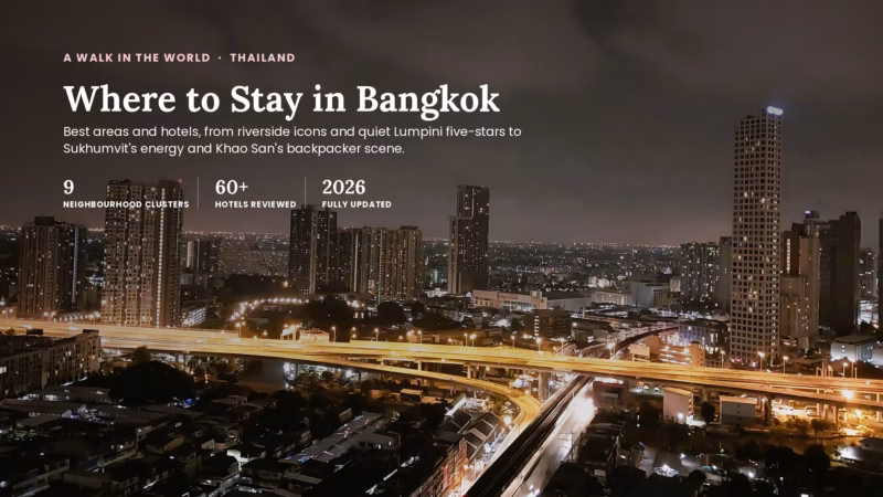 Aerial night view of Bangkok's skyline with an illuminated elevated expressway curving past high-rise condos near the Chao Phraya