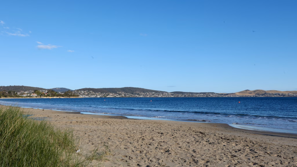 Bellerive Beach with marram grass tuft foreground and the Derwent River behind