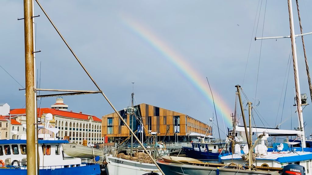 A rainbow arcing over Hobart's waterfront fishing boats after a rain shower