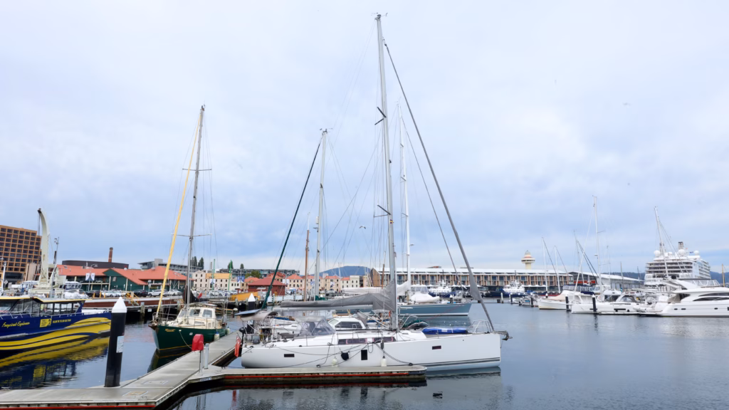 Sailing boats moored at Hobart's waterfront marina with the Derwent River behind