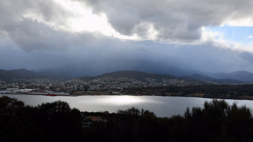Hobart CBD across the Derwent River from Rosny Hill Lookout with light breaking through cloud