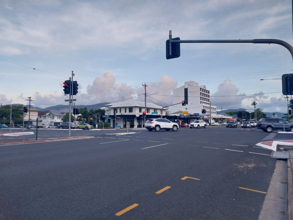 A street intersection on Sheridan Street at dusk, with the Alivio Hotel visible in the background and traffic passing through