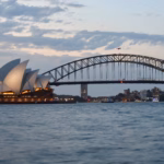 Sydney Opera House and Harbour Bridge seen together across the harbour at dusk
