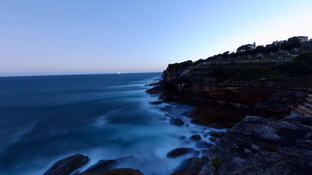 Sandstone cliffs and ocean along the Bondi to Coogee coastal walk at dusk