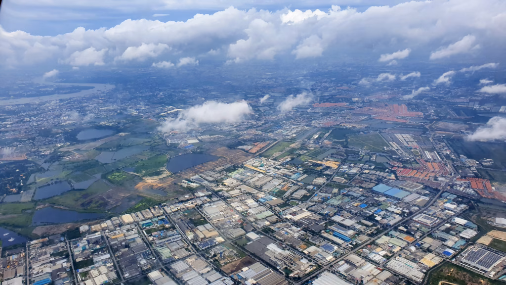 Aerial view of Bangkok's outskirts and the Chao Phraya River from the plane window