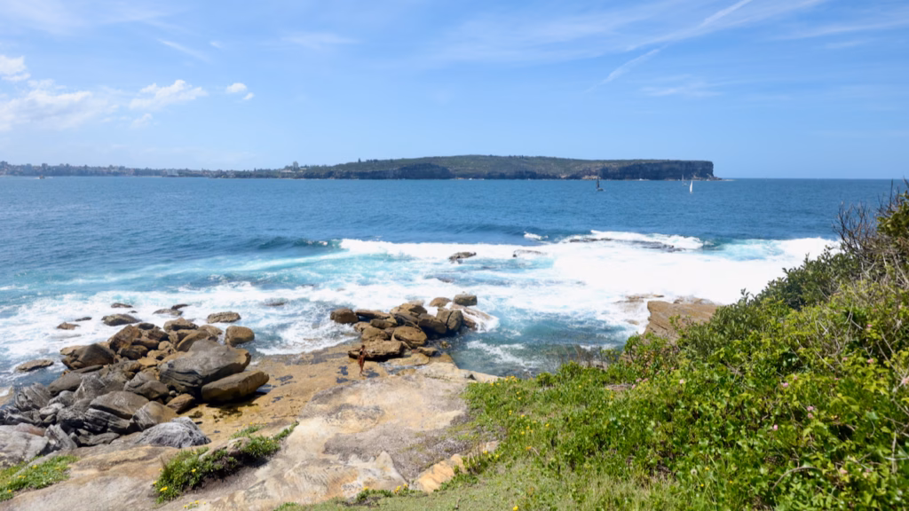 Waves breaking over sandstone rock platforms at South Head, Watsons Bay, with North Head across the Sydney Harbour entrance
