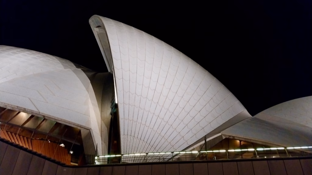 Several Sydney Opera House sail shapes fanned out close together, night close-up detail shot