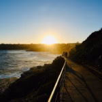 Walkers on the Bondi to Coogee walk heading towards the setting sun near Marks Park