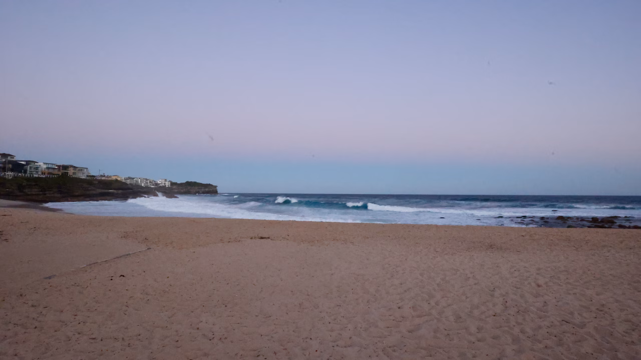 Bronte Beach at blue hour with waves breaking and the northern headland behind