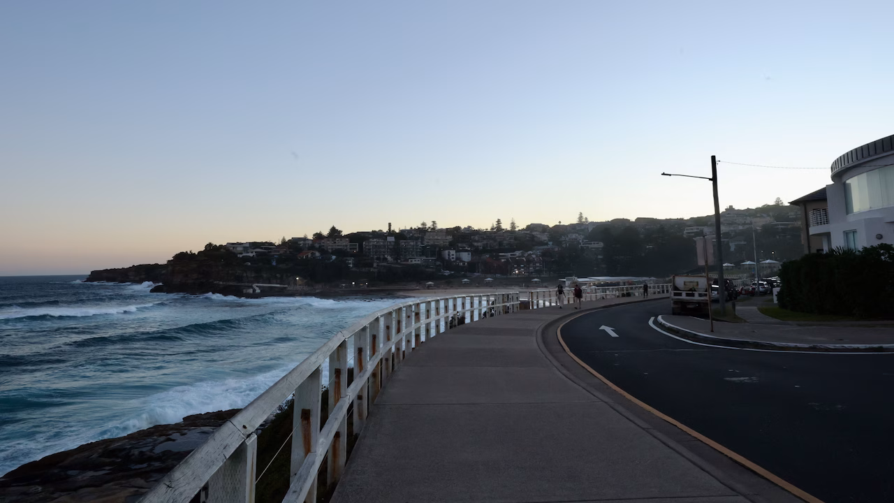 The coastal walk footpath along Bronte Marine Drive at dusk with Bronte Beach ahead