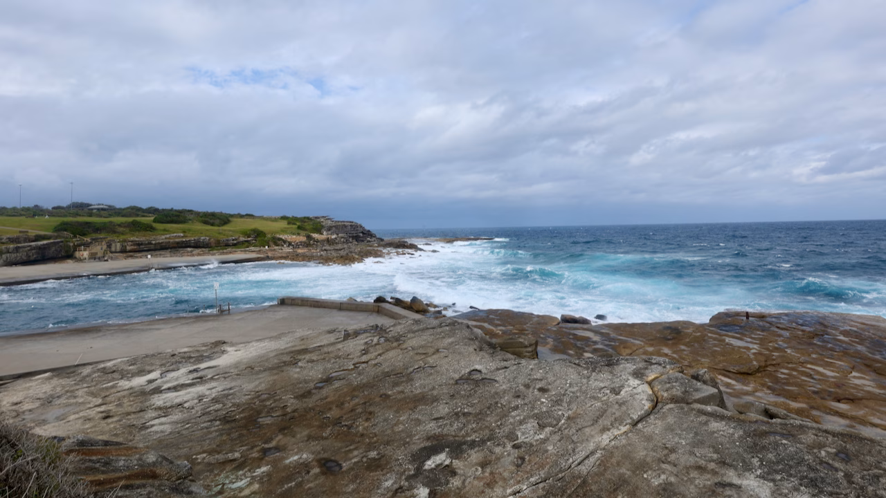 Clovelly Beach inlet with Burrows Park on the clifftop beyond