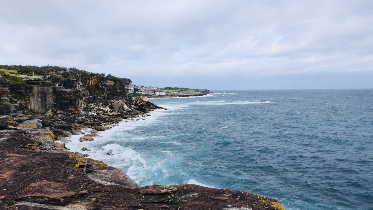 Sheer sandstone cliffs and rough sea at Dunningham Reserve near Coogee