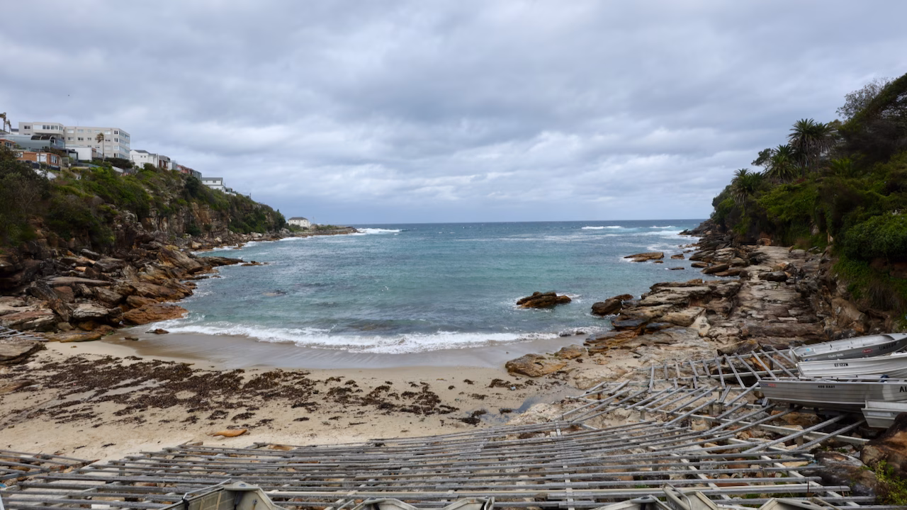 Aluminium dinghies on wooden racks at Gordons Bay between Clovelly and Coogee