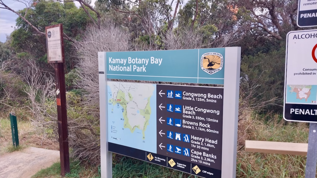 Kamay Botany Bay National Park sign with a map and distances to Congwong Beach, Little Congwong Beach, Browns Rock, Henry Head and Cape Banks